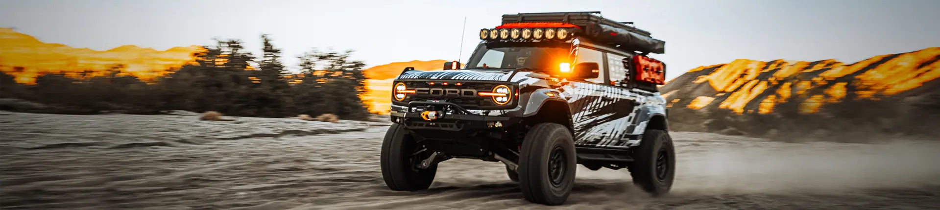Bronco Raptor on a dirt road with sunrise in the background