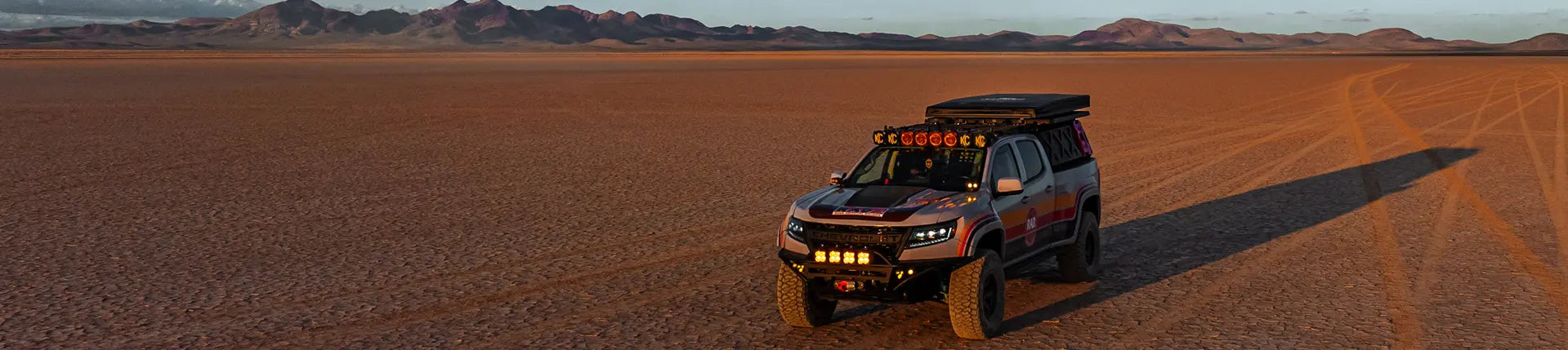 Off-road Chevy Colorado in a desert landscape with mountains in the background